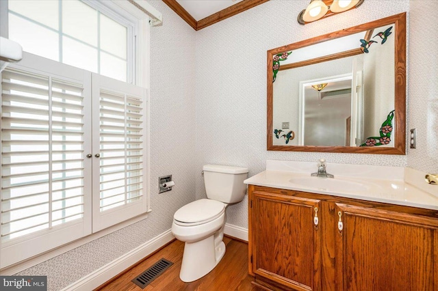 half bath featuring visible vents, a healthy amount of sunlight, wallpapered walls, and toilet