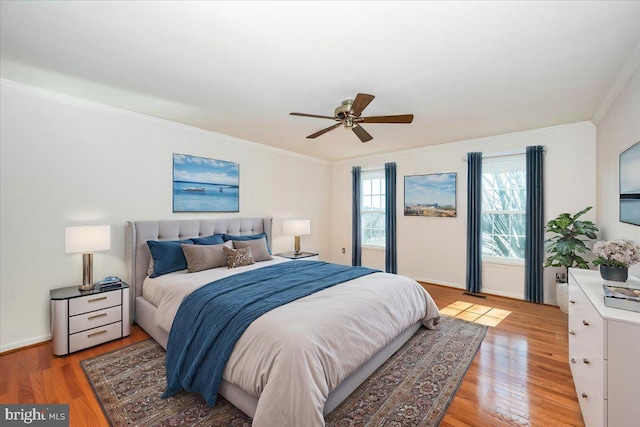 bedroom with light wood-style flooring, baseboards, crown molding, and ceiling fan