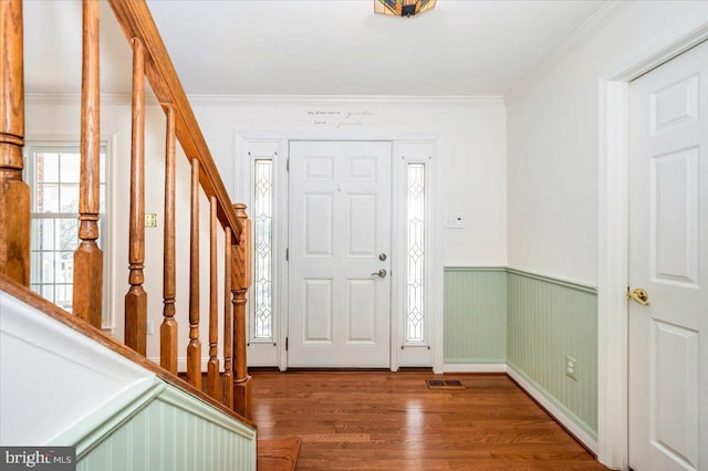 entryway with stairway, wood finished floors, and ornamental molding