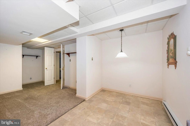 finished below grade area featuring visible vents, baseboards, a paneled ceiling, light carpet, and baseboard heating