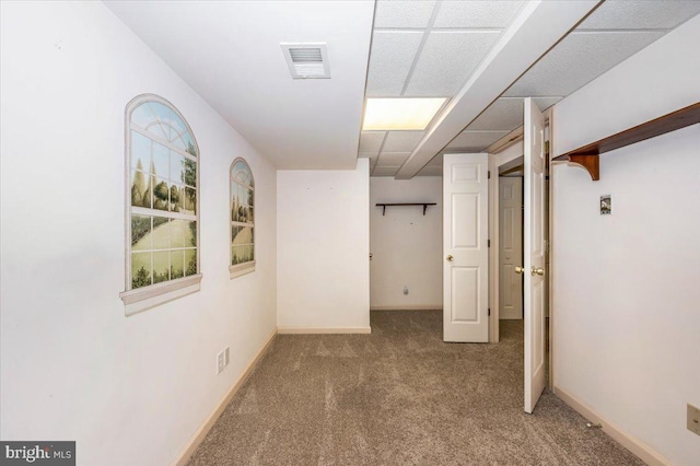 basement with visible vents, baseboards, and carpet