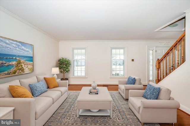 living area with stairs, baseboards, light wood finished floors, and ornamental molding