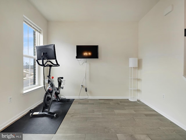 exercise area featuring baseboards and wood finished floors