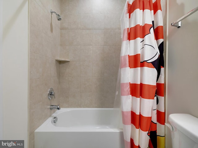 bathroom featuring toilet and shower / bath combination with curtain