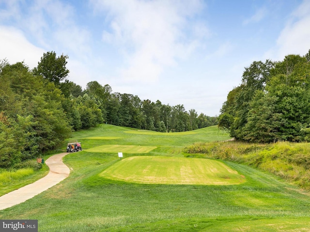 surrounding community with view of golf course and a yard