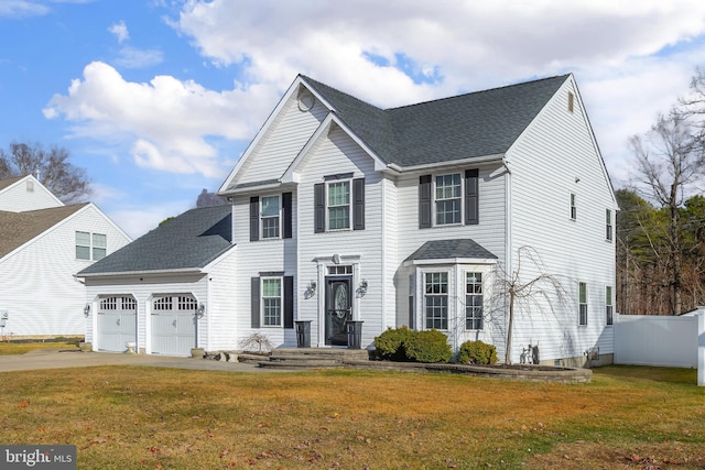 view of front of property with a garage, concrete driveway, a front yard, and fence