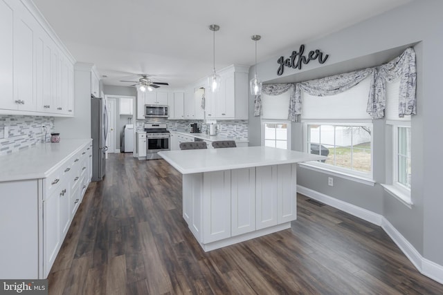 kitchen featuring appliances with stainless steel finishes, light countertops, white cabinetry, and decorative backsplash