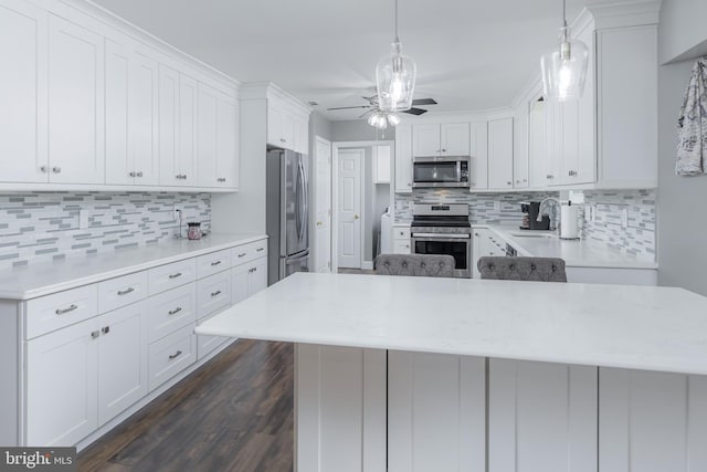 kitchen with stainless steel appliances, light countertops, dark wood finished floors, and decorative backsplash