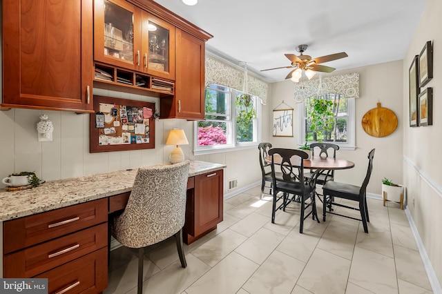dining area featuring visible vents, built in study area, ceiling fan, and baseboards