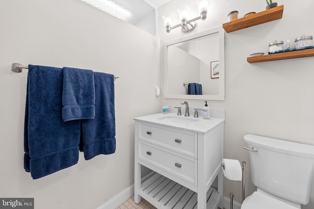 bathroom with baseboards, toilet, and vanity