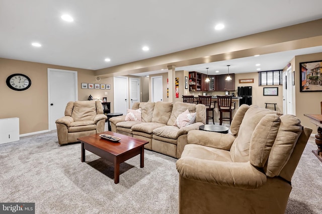 living area with recessed lighting, bar, and light carpet