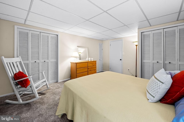 bedroom with a paneled ceiling, carpet, and baseboards