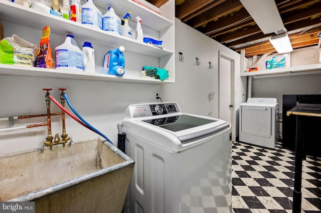 clothes washing area featuring a sink, washing machine and clothes dryer, laundry area, and tile patterned floors