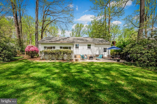 rear view of house with a lawn and a patio area