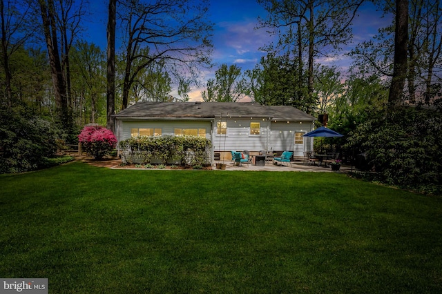 back of house with a patio area and a yard