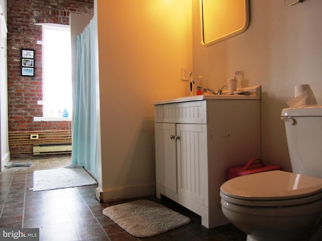 bathroom featuring toilet, brick wall, baseboards, baseboard heating, and vanity