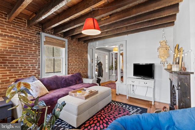 living area featuring wood finished floors, baseboards, brick wall, wood ceiling, and beamed ceiling