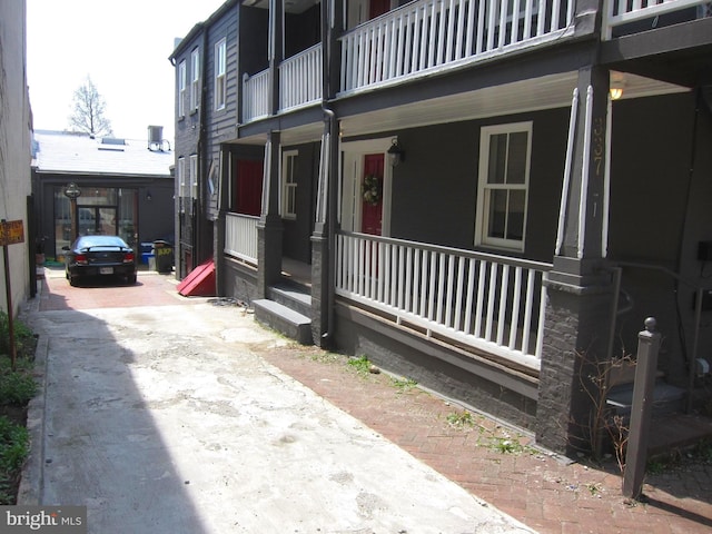 view of side of property featuring a porch and driveway