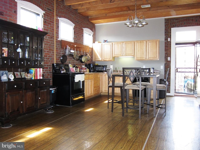 kitchen featuring beamed ceiling, plenty of natural light, black appliances, and dark wood finished floors