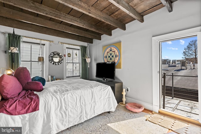 bedroom with wooden ceiling, beamed ceiling, multiple windows, and baseboards