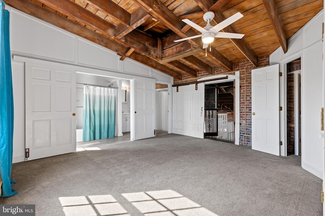 unfurnished bedroom featuring lofted ceiling with beams, wooden ceiling, and carpet flooring