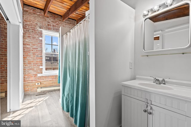 full bath with beam ceiling, baseboard heating, wood finished floors, and brick wall