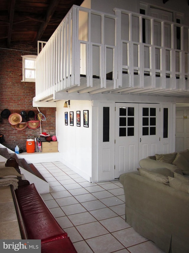 interior space with light tile patterned floors and brick wall