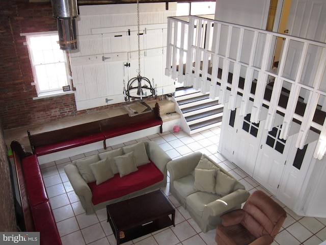 living room with tile patterned flooring and brick wall