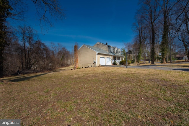 view of home's exterior with driveway, a lawn, and an attached garage