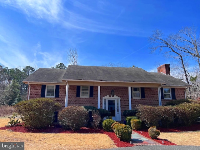 split foyer home featuring brick siding and a chimney