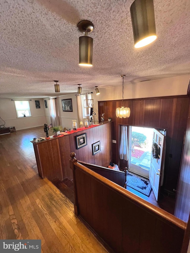interior space featuring light wood-style floors, pendant lighting, and a textured ceiling