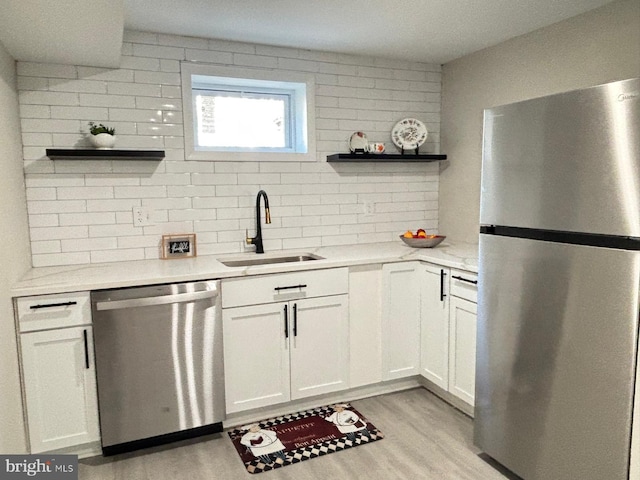 kitchen with a sink, appliances with stainless steel finishes, white cabinetry, and open shelves