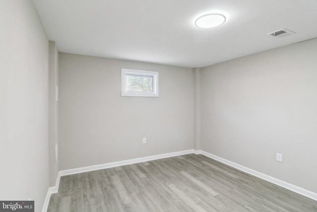 unfurnished room featuring visible vents, wood finished floors, and baseboards