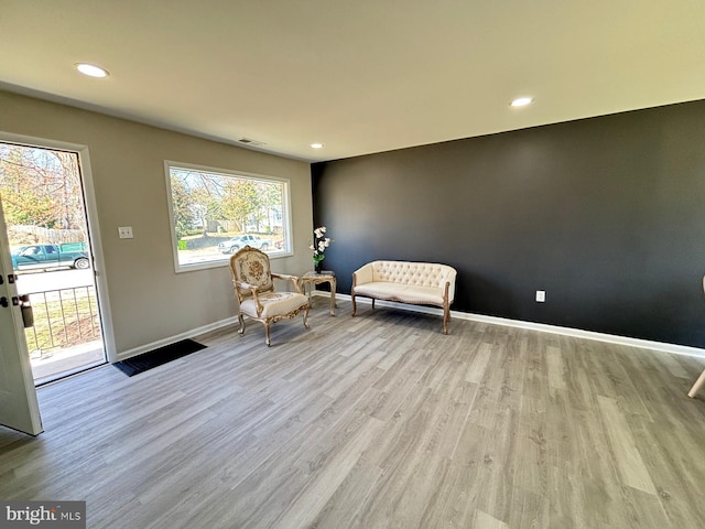 unfurnished room with visible vents, a healthy amount of sunlight, baseboards, and wood finished floors