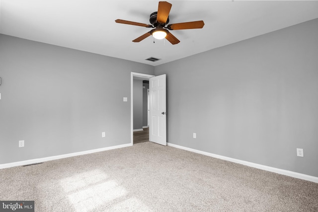 empty room with a ceiling fan, carpet, visible vents, and baseboards