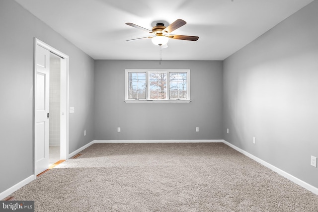 spare room with carpet flooring, a ceiling fan, and baseboards