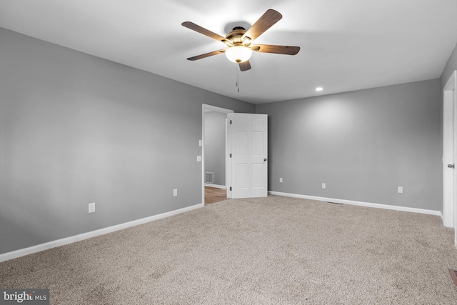 spare room featuring carpet flooring, ceiling fan, visible vents, and baseboards