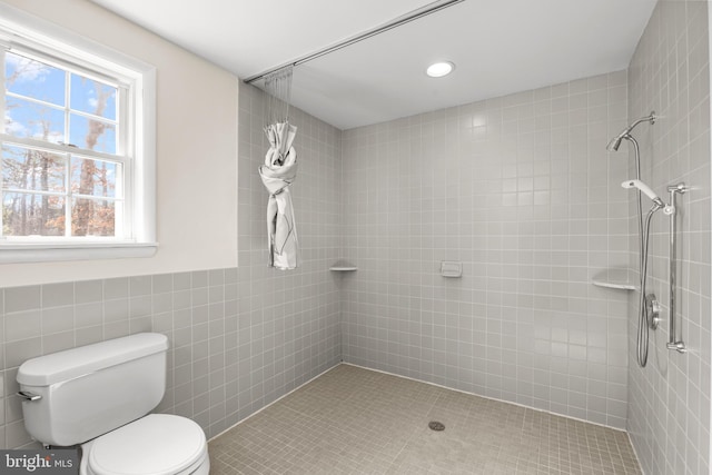 full bathroom featuring toilet, tile walls, tiled shower, and recessed lighting