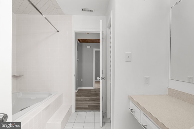 bathroom featuring visible vents, vanity, a bathing tub, and tile patterned floors