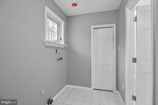 laundry area with laundry area, light tile patterned flooring, and baseboards