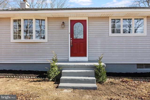 view of exterior entry with a chimney