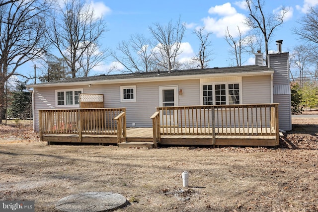 back of house featuring a chimney and a wooden deck