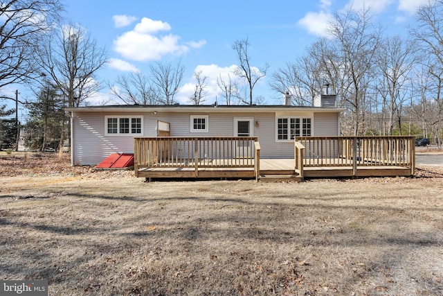 rear view of property with a chimney and a wooden deck