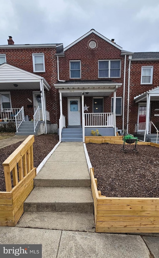 view of front facade featuring brick siding and covered porch