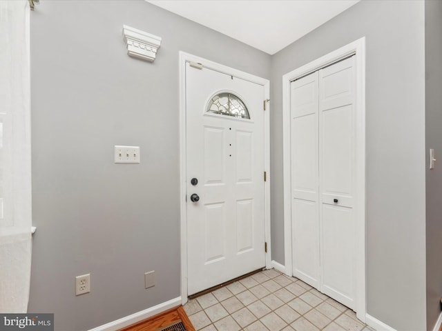 entrance foyer with light tile patterned floors and baseboards