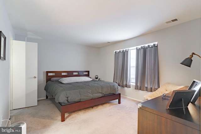 bedroom featuring light carpet, visible vents, and baseboards