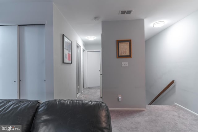 interior space featuring baseboards, visible vents, and light colored carpet