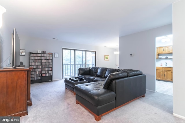 living area featuring baseboards and light colored carpet