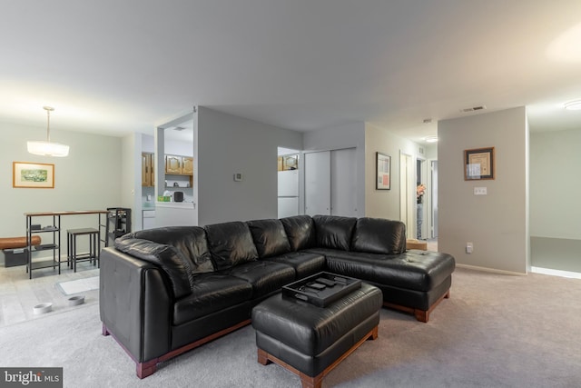 living room with light colored carpet, visible vents, and baseboards