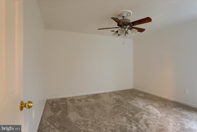 carpeted spare room with ceiling fan and baseboards